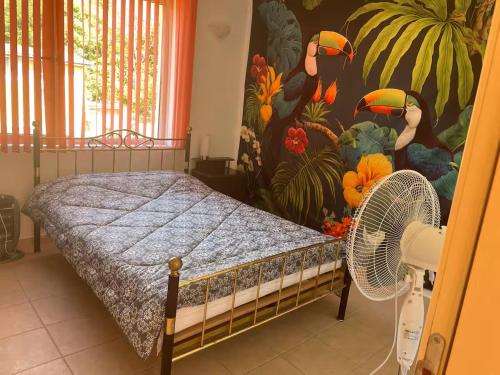 a bedroom with a bed with a fan and a mural at Apartment Siana in Balchik