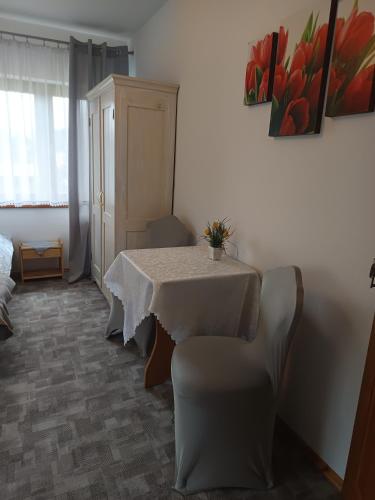 a dining room with a table and a chair at Spokojna Zagroda in Biały Dunajec