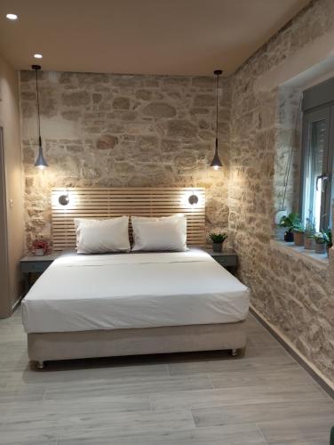 a bedroom with a large bed in a stone wall at isogion in Pitsidia