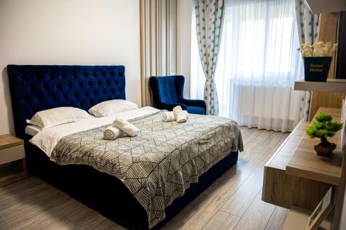 a bedroom with a blue bed and a blue chair at Q Elegance Palas Mall in Iaşi