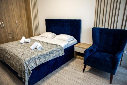 a bedroom with a bed and a blue chair at Q Elegance Palas Mall in Iaşi