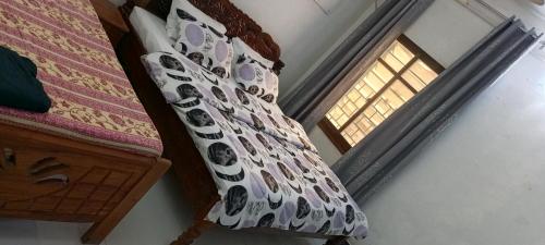 a curtain on a bed with a window in a room at Balcony Bliss & Private Bath at Mamdalis in Ngambo
