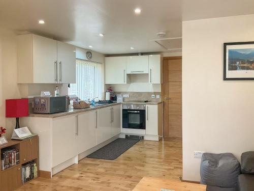 a small kitchen with white cabinets and a kitchen at Thistle Dubh in Drumnadrochit