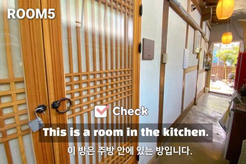 a room in the kitchen with a door and a sign at Pungnam House in Jeonju