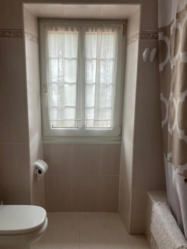 a bathroom with a toilet and a window at Hostal Ekaitza in Lesaka