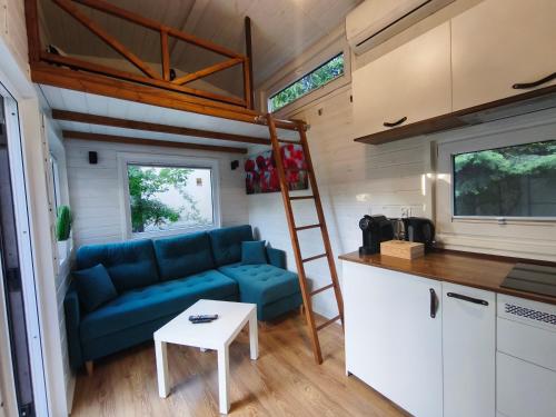 a living room with a blue couch in a tiny house at City TinyHouse under WaterTower in Wrocław