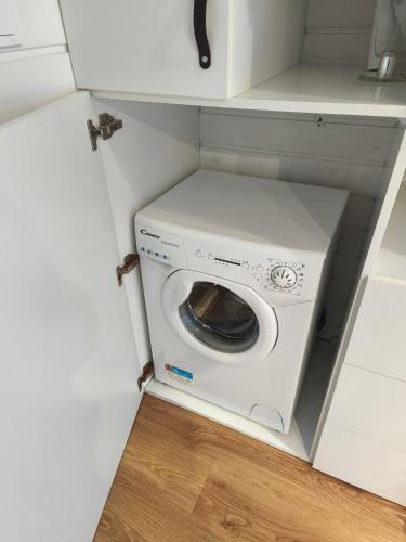 a washer and dryer in a small kitchen at City TinyHouse under WaterTower in Wrocław