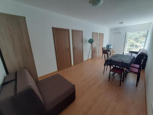 a living room with a couch and a table and chairs at Nino Lux Apartments Ulcinj in Ulcinj