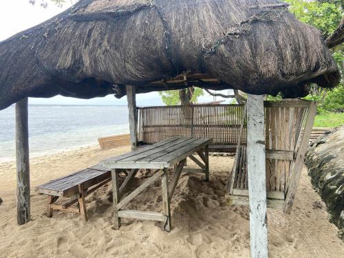 a picnic table and an umbrella on the beach at Jp baybay view beach resort in Bolinao