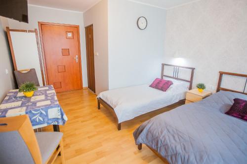 a room with two beds and a table with a desk at PIKA Pokoje Gościnne in Władysławowo