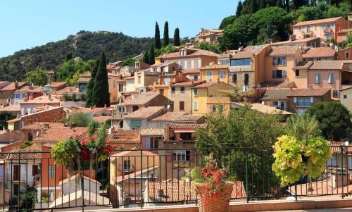 ein Dorf auf einem Hügel mit Häusern in der Unterkunft Appartement T2 chambre plus cabine, terrasse vue piscine in Bormes-les-Mimosas