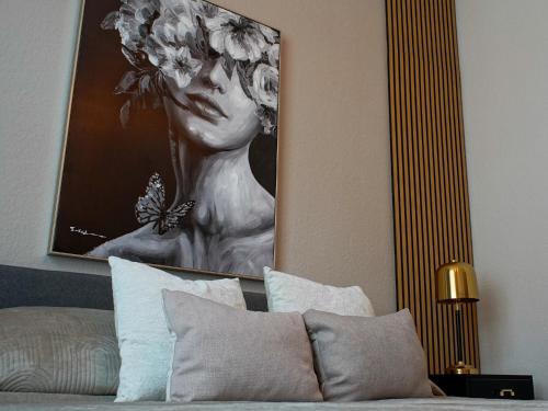 a picture of a woman with areath of flowers above a bed at Brandneu - Fewo Sweethome mitten in Lutherstadt Wittenberg - ruhige Seitenstraße - eigener Parkplatz - Einkaufen, Restaurants & Schlosskirche 2 Min zu Fuß - Waschmaschine - Smart-TV - vollausgestattet in Lutherstadt Wittenberg