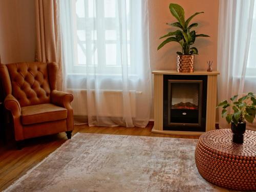 a living room with a chair and a fireplace at Brandneu - Fewo Sweethome mitten in Lutherstadt Wittenberg - ruhige Seitenstraße - eigener Parkplatz - Einkaufen, Restaurants & Schlosskirche 2 Min zu Fuß - Waschmaschine - Smart-TV - vollausgestattet in Lutherstadt Wittenberg