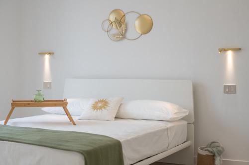 a bedroom with a bed with white sheets and a table at Armonia Suites - Terra e Acqua in Verona