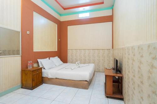 a bedroom with a bed and a tv in it at SAHABAT Hotel Tangerang By Reccoma in Kampungbaru