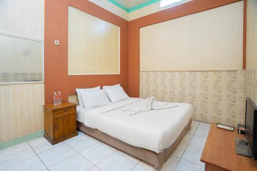 a bedroom with a large bed and a television at SAHABAT Hotel Tangerang By Reccoma in Kampungbaru