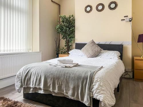 a bed with a white blanket and a bowl on it at Heart Of The Valleys in Ebbw Vale