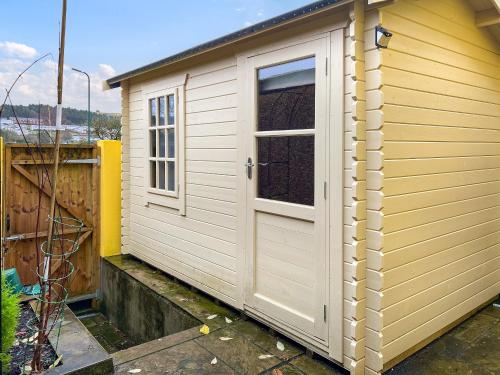 a small shed with a door and a window at Heart Of The Valleys in Ebbw Vale
