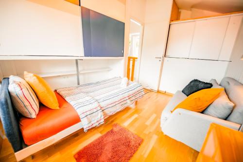 a living room with an orange couch and a white couch at Villa en plein cœur de Leysin in Leysin