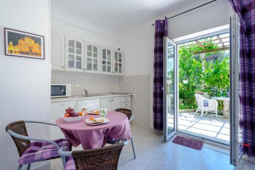 a kitchen with a table with a bowl of fruit on it at Apartments Milić in Mlini