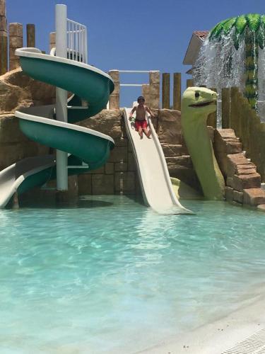 a man riding a slide at a water park at Cadaques Caribe Pez 103 in Bayahibe