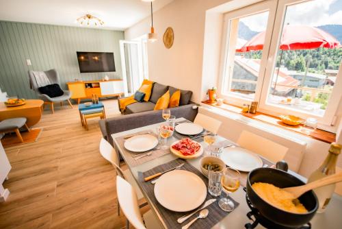 a dining room and living room with a table and chairs at Villa en plein cœur de Leysin in Leysin