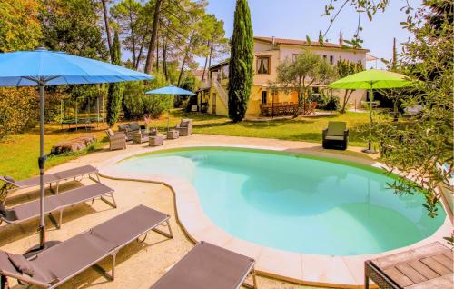 a large swimming pool with chairs and umbrellas at Gorgeous Home In Aubenas in Aubenas