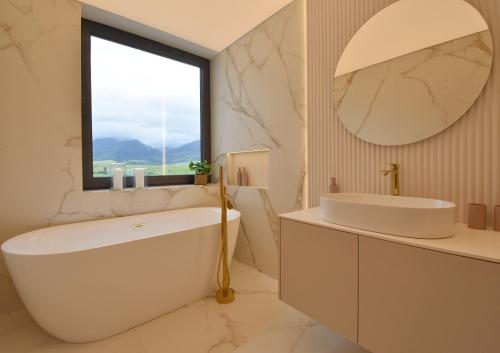 Un baño con bañera, lavabo y espejo. en GOLD Apartment, en Rajecké Teplice