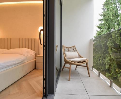 1 dormitorio con 1 cama y 1 silla junto a una ventana en GOLD Apartment, en Rajecké Teplice