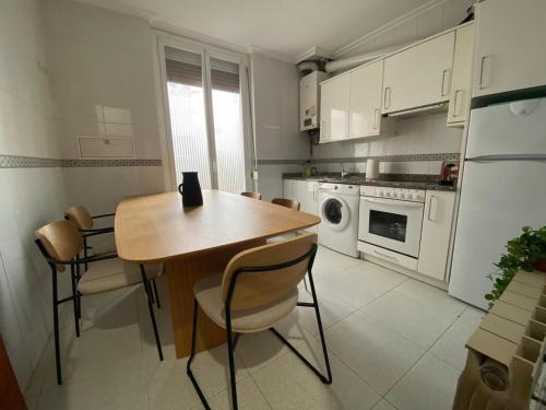 a small kitchen with a wooden table and chairs at Tejería 43 by Clabao in Pamplona
