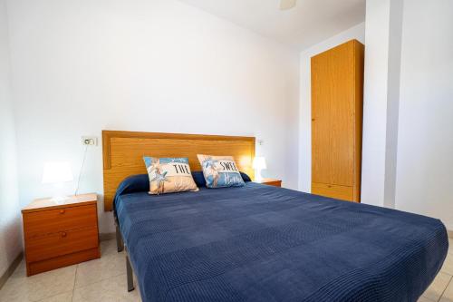 a bedroom with a blue bed with two pillows at ED. MISTRAL VIDABER in Oropesa del Mar