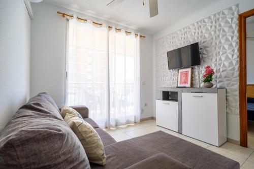 a living room with a couch and a tv at ED. MISTRAL VIDABER in Oropesa del Mar