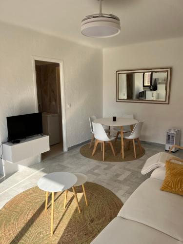 un salon avec un canapé et une table avec des chaises dans l'établissement Studio lumineux et spacieux avec balcon proche Garibaldi, à Nice