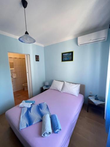 a bedroom with a purple bed with towels on it at Room Vera in Senj