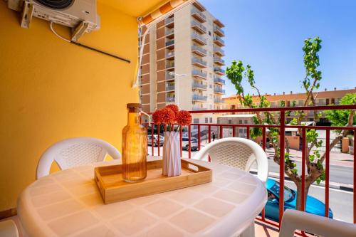 a table with a bottle and flowers on a balcony at ED. MISTRAL VIDABER in Oropesa del Mar