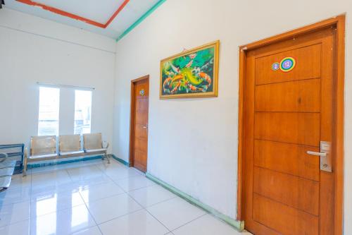 a waiting room with a door and a picture on the wall at SAHABAT Hotel Tangerang By Reccoma in Kampungbaru