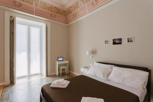 een slaapkamer met een bed met twee handdoeken erop bij Mungibeddu Organic Bed and Breakfast in Catania