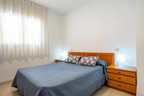 a bedroom with a blue bed with two pillows on it at ED. MISTRAL VIDABER in Oropesa del Mar