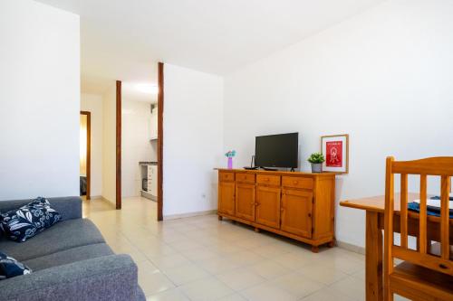 a living room with a couch and a tv on a cabinet at ED. MISTRAL VIDABER in Oropesa del Mar