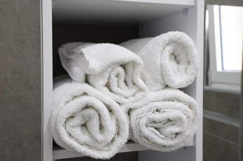 a pile of white towels sitting on a shelf at A&K Apartments in Sarandë