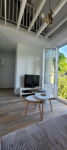 a living room with a coffee table and a tv at Le Birdie - Maison & Jardin à proximité de Chantilly in Vineuil-Saint-Firmin