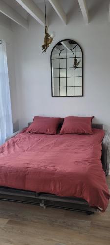 a bedroom with a bed with red sheets and a window at Le Birdie - Maison & Jardin à proximité de Chantilly in Vineuil-Saint-Firmin