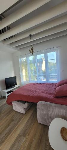 a bedroom with a large bed and a large window at Le Birdie - Maison & Jardin à proximité de Chantilly in Vineuil-Saint-Firmin