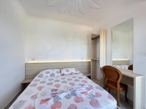 a bedroom with a bed and a desk and a mirror at Villa Kasa in Durrës