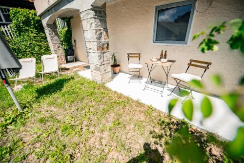 a patio with chairs and a table in the yard at Villa en plein cœur de Leysin in Leysin