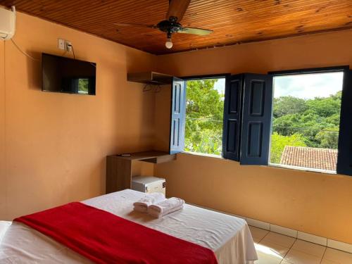 a bedroom with a bed and two windows at Pousada Brilho da Chapãda in Lençóis