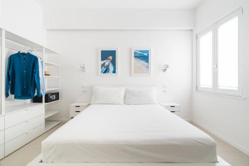 a white bedroom with a large bed and a window at Puolo Seaside Apartment 3 in Massa Lubrense