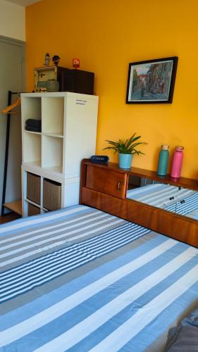 a bedroom with a bed and a yellow wall at Chambre dans appartement agréable et calme à 15 mn du Centre Ville in Annecy