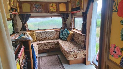 an interior of a camper with a couch and window at Countryside Caravan in Saint-Michel-de-Montjoie