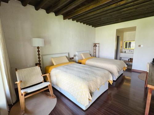 a bedroom with two beds and a chair in it at Dali Healing Yard 喜洲禾隐星登 in Dali